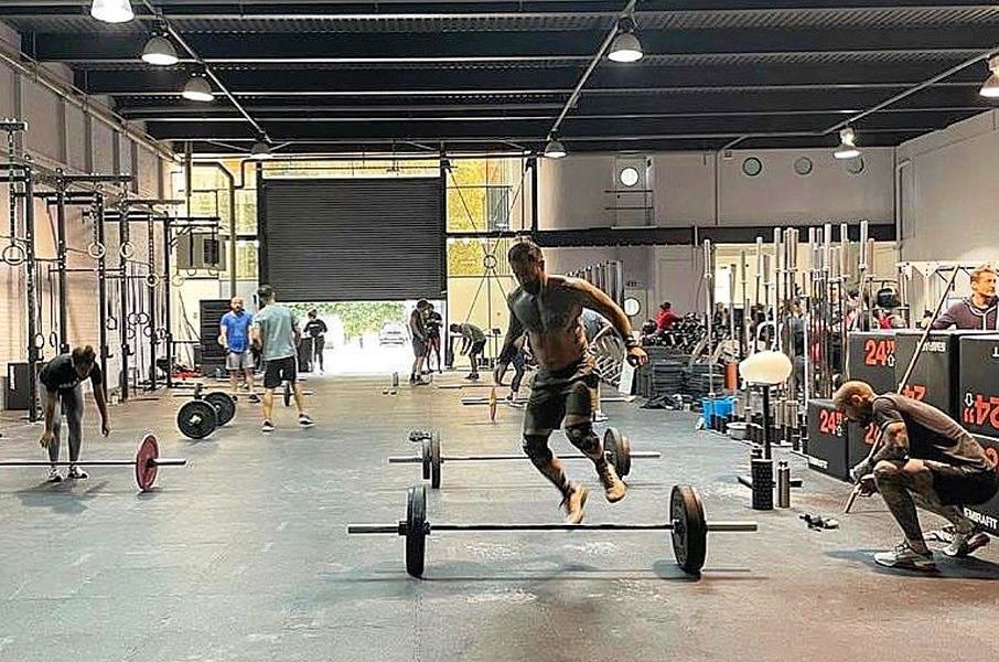 man jumping over barbell